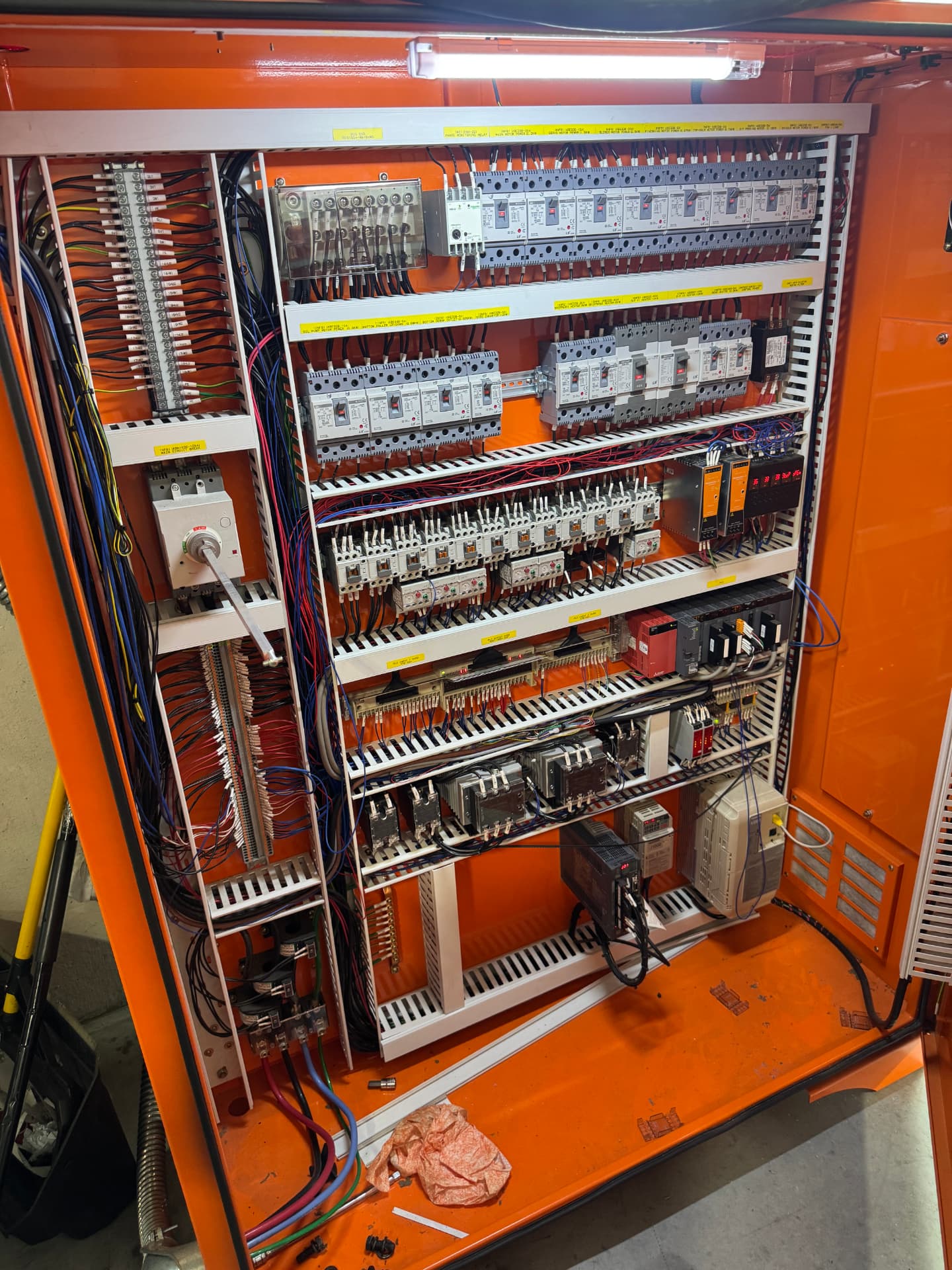 Before: existing orange MCC-style panel with breakers, contactors, and VFDs prior to cleanup and reorganization